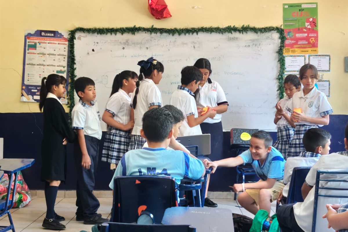 Estudiantes universitarios desarrollando una actividad educativa con un grupo escolar