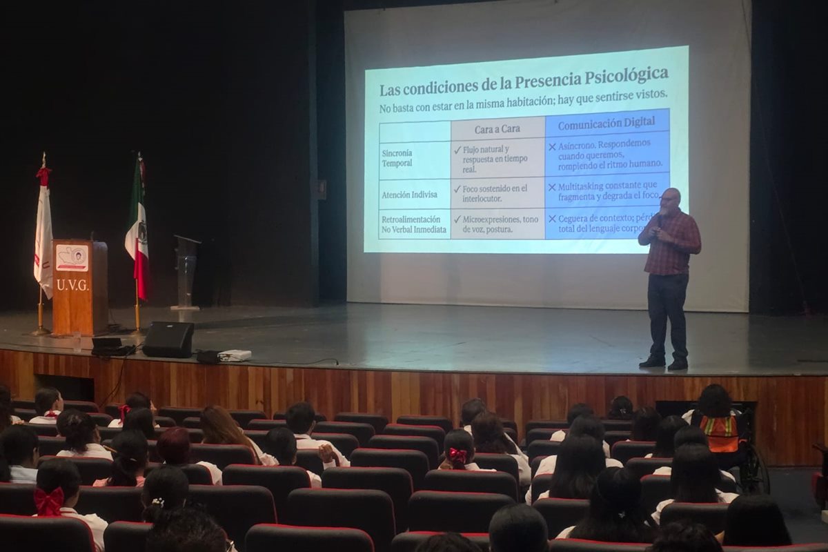 Comunidad universitaria asistiendo a una conferencia en un auditorio